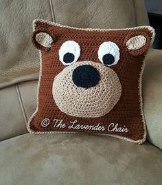 a crocheted bear pillow sitting on top of a couch