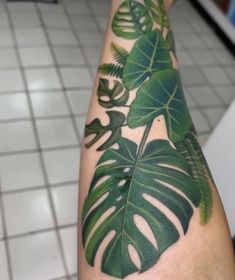 a person with a green leaf tattoo on their arm