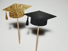 two black and gold graduation hats on top of toothpicks in the shape of a graduate's cap