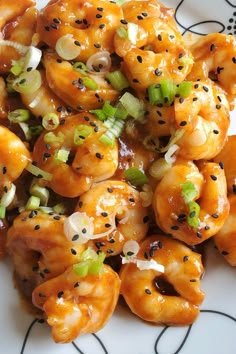 a white plate topped with shrimp covered in sesame seeds