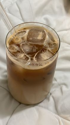 an iced drink in a glass with ice cubes on the rim and a straw sticking out of it