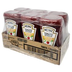 three bottles of heinz's tomato ketchup sitting in a cardboard box