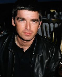 a man wearing a black leather jacket sitting next to a woman