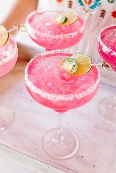 three pink margaritas sitting on top of a table