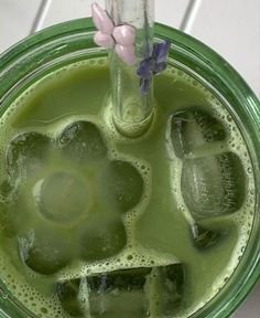 a green drink with ice cubes in it