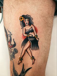 a woman with a hula skirt tattoo on her leg is shown from the waist up