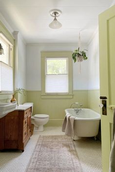 a bathroom with a tub, toilet and sink in it's center area is shown