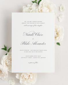 a wedding card with white flowers and greenery