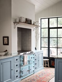 a kitchen with blue cabinets and an area rug