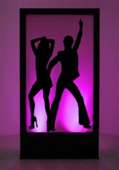 the silhouettes of two people dancing in front of a purple background