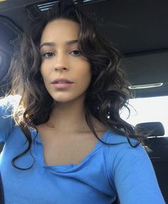 a woman sitting in the back seat of a car with her hand on her hip