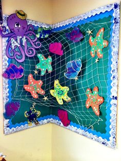 a wall hanging with an octopus and other sea creatures on it's side in a child's room