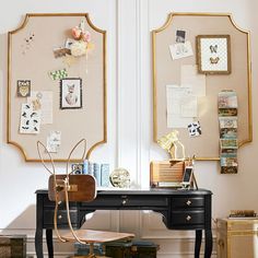 a black desk topped with a wooden chair next to a wall covered in pictures