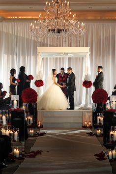 an image of a couple getting married in front of the wedding ceremony arch with candles and flowers