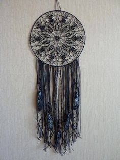 a black and white dream catcher hanging on a wall