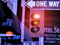 a traffic light with one way signs above it and another sign on the other side