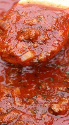 a spoon full of sauce with meatballs in it