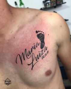 a close up of a person's chest with a baby foot tattoo on it