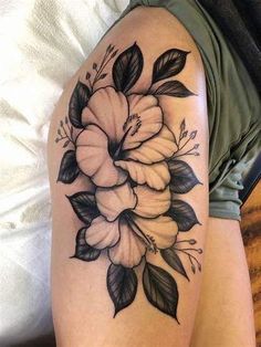 a woman's thigh with flowers and leaves on it