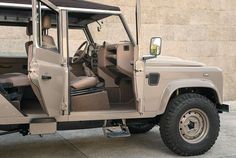 an off - road vehicle is parked in front of a building with its doors open