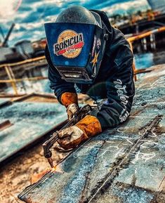 a man wearing a helmet and holding a wrench on top of a roof