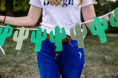 a woman is holding some paper cactus garlands