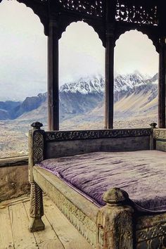 a bed sitting in the middle of a room with mountains in the background