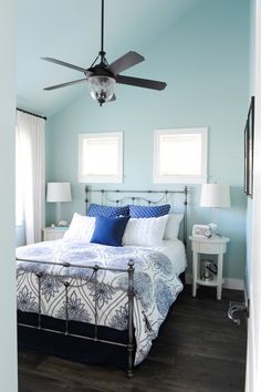 a bedroom with blue walls and ceiling fan