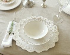 the table is set with white plates and silverware