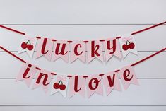 two valentine's day buntings with cherries and the words lucky in love