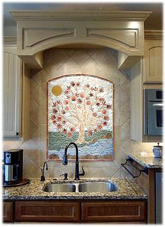 a kitchen with a sink, stove and oven in it's corner area next to a painting on the wall