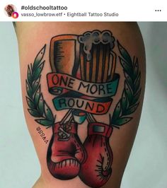 a tattoo with two boxing gloves and a beer on the bottom half of the thigh