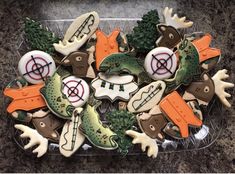 decorated cookies in the shape of alligators and deer on a clear platter,