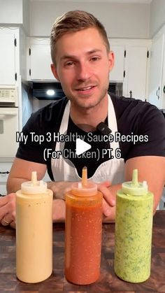 a man sitting at a kitchen counter with three different sauces in front of him