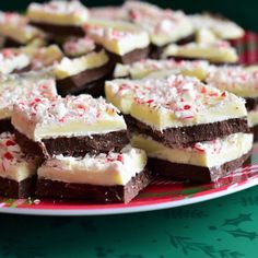 a chocolate cake with white frosting and sprinkles on top is cut into pieces