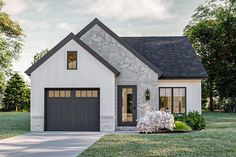 a white house with black garage doors and windows