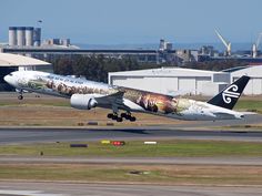 an air plane taking off from the runway at an airport with buildings in the background