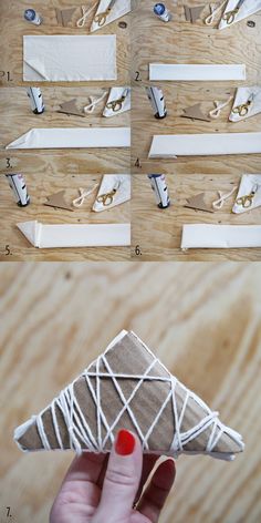 a person holding up a paper airplane on top of a wooden table next to other pieces of wood