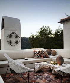 an outdoor seating area with chairs and pillows