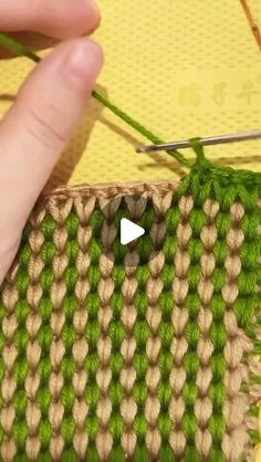 the video shows how to use knitting needles and yarns for weaving on fabric or knitted material