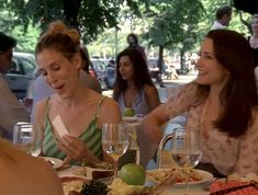 two women sitting at a table with plates of food