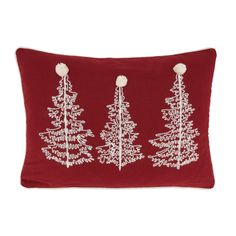 three christmas trees on a red pillow with pom poms hanging from the back