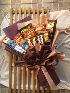 a basket filled with candy and candies on top of a wooden chair next to a white sheet