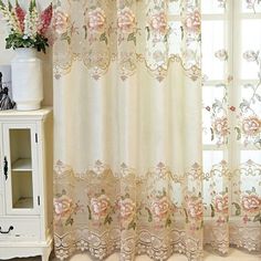 the curtains are decorated with pink flowers on them and white vases next to it