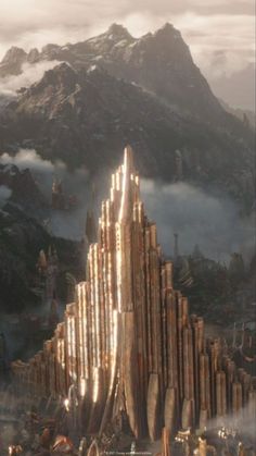 a futuristic city surrounded by mountains and fog