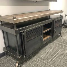 a large entertainment center in an office with metal and wood accents on the top shelf