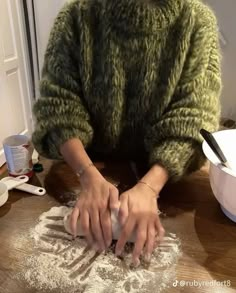 a woman is kneading dough on the table with her hands and making it