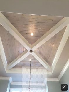 a ceiling with wooden beams and a chandelier hanging from it