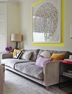 a living room filled with furniture and a painting on the wall