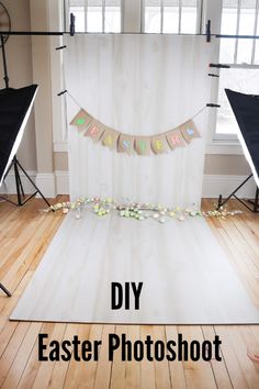 an easter photo shoot with white backdrop and bunting on the floor in front of two windows